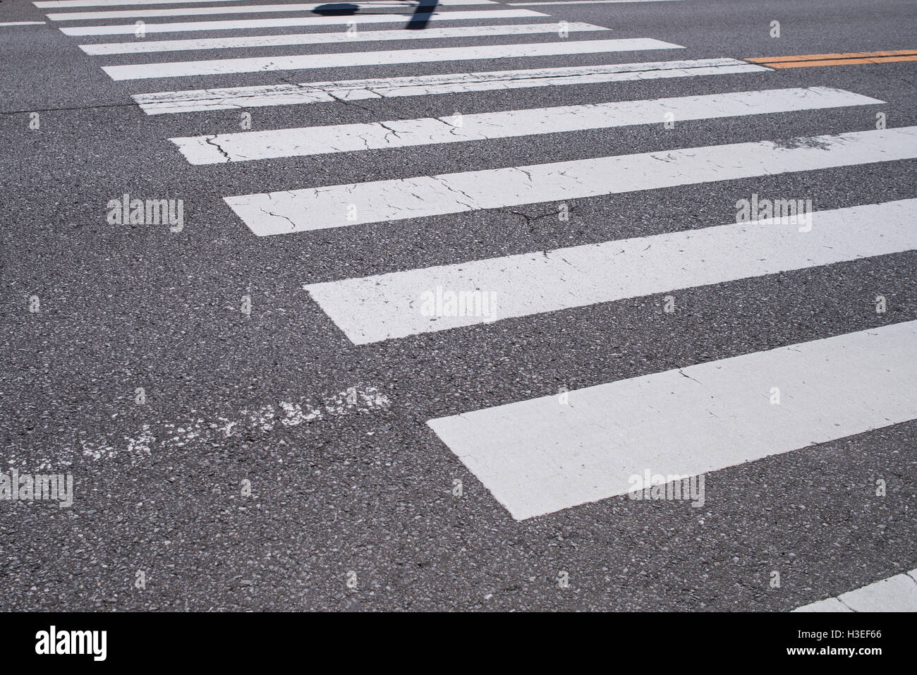 Attraversamento pedonale con la segnaletica stradale. Linee bianche sul buio strada asfaltata,Giappone Foto Stock