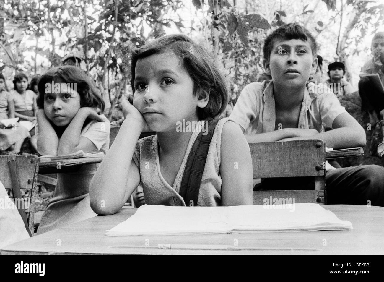 CHALATENANGO EL SALVADOR, FEB 1984: - all'interno del FPL Guerrilla zone di controllo - un misto di bambini e adulti corsi di alfabetizzazione svolgono ogni giorno sotto gli alberi per evitare di essere intercettata dal airforce. Foto Stock