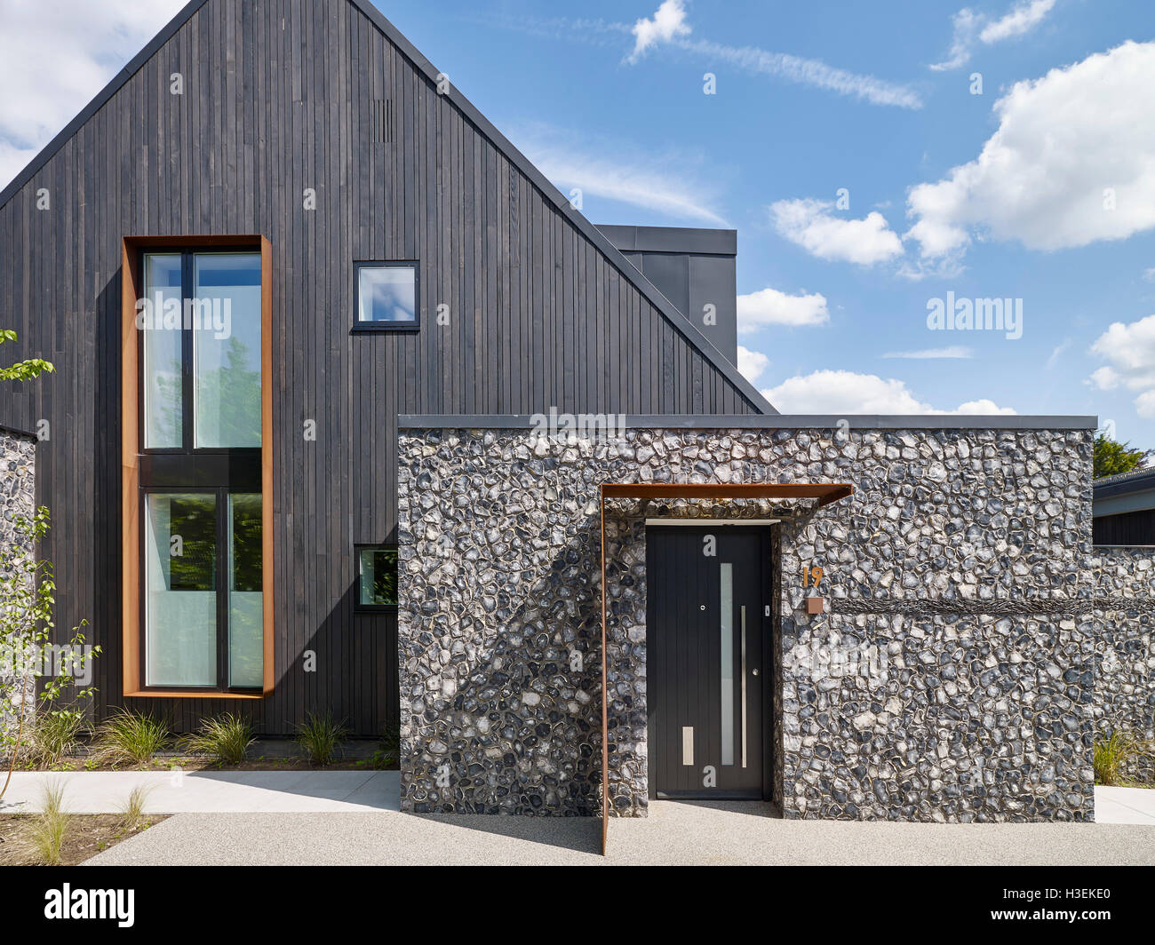 Ingresso alla casa. In elevazione frontale e con la selce e arrugginita in acciaio corten. House 19, Old Amersham, Regno Unito. Architetto: Jestico + Whiles, 2016. Foto Stock