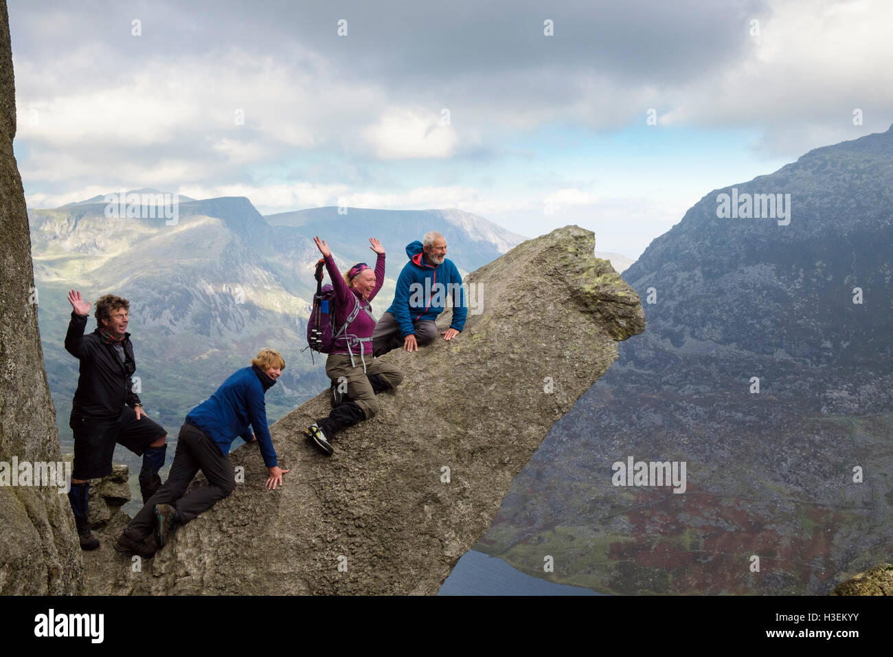 Felice escursionisti sulla roccia di cannone sul monte Tryfan nord cresta sopra la valle Ogwen nelle montagne del Parco Nazionale di Snowdonia (Eryri). Wales UK Foto Stock