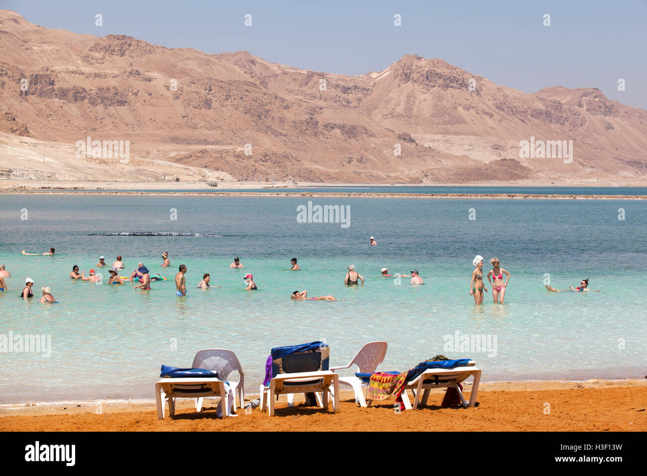 I turisti che nuotano all'interno delle acque salate del Mar Morto. Ein Bokek, Israele. Foto Stock