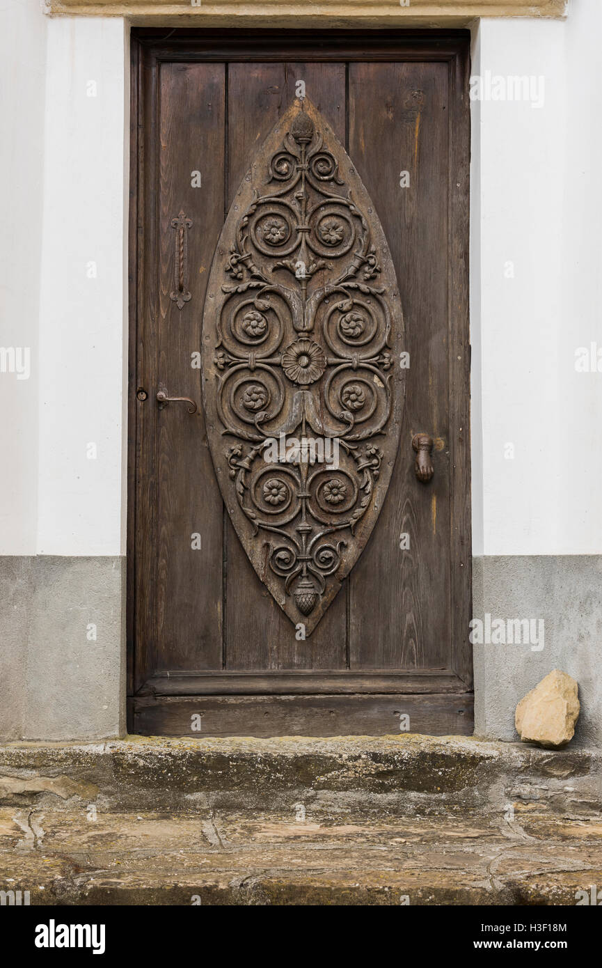 Vecchio scolpita in legno e porta storta di Montechiaro d'Acqui, Piemonte, Italia Foto Stock