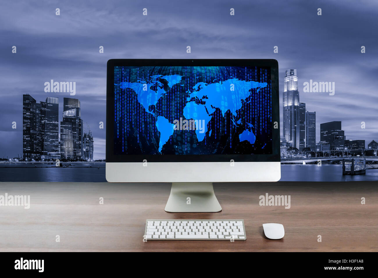 Sullo schermo del computer sul tavolo di legno nel moderno business office con la notte di Singapore centro business district. Il concetto di business. Foto Stock