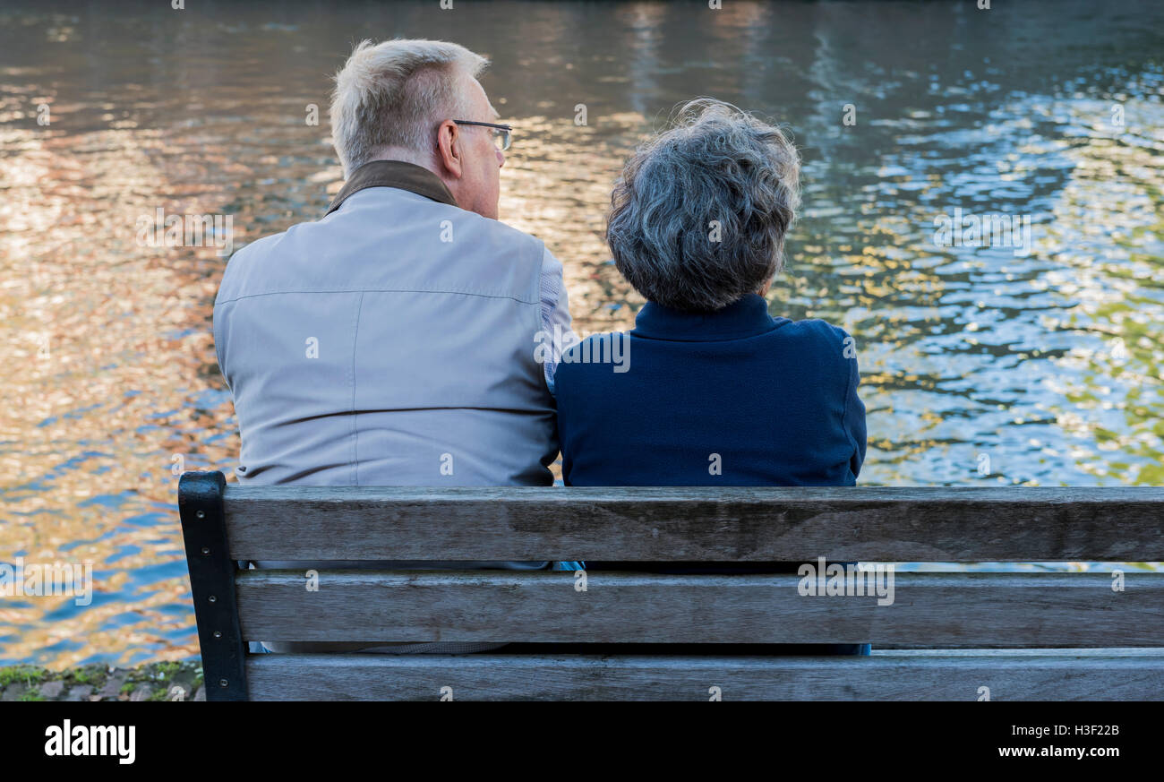 Utrecht, Paesi Bassi - 6 Agosto 2016: due persone, una donna e un uomo seduto su una panchina e guardare all'acqua. Foto Stock
