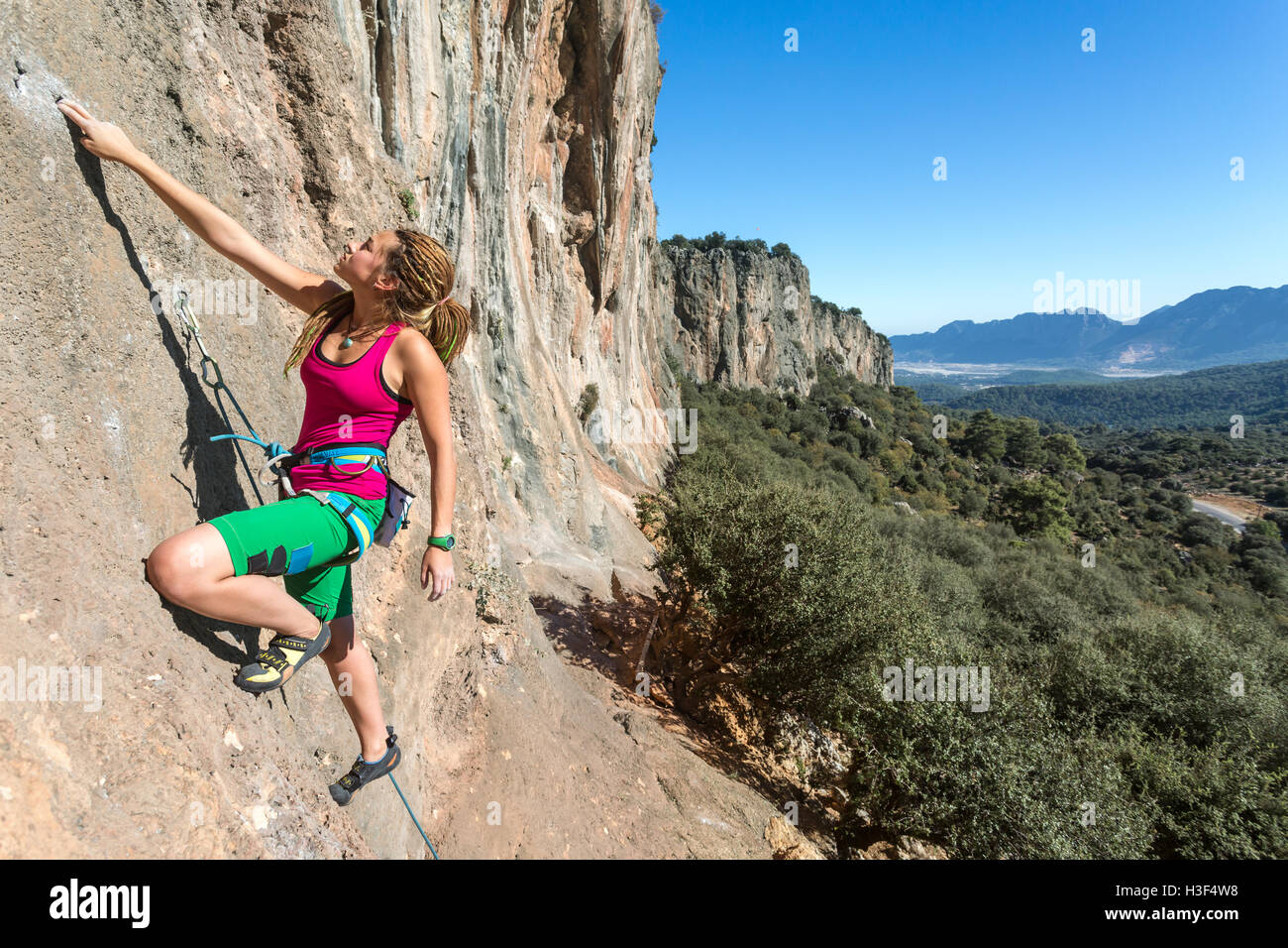 Stile Hippie scalatore femmina verticale ascendente Orange Rock Foto Stock