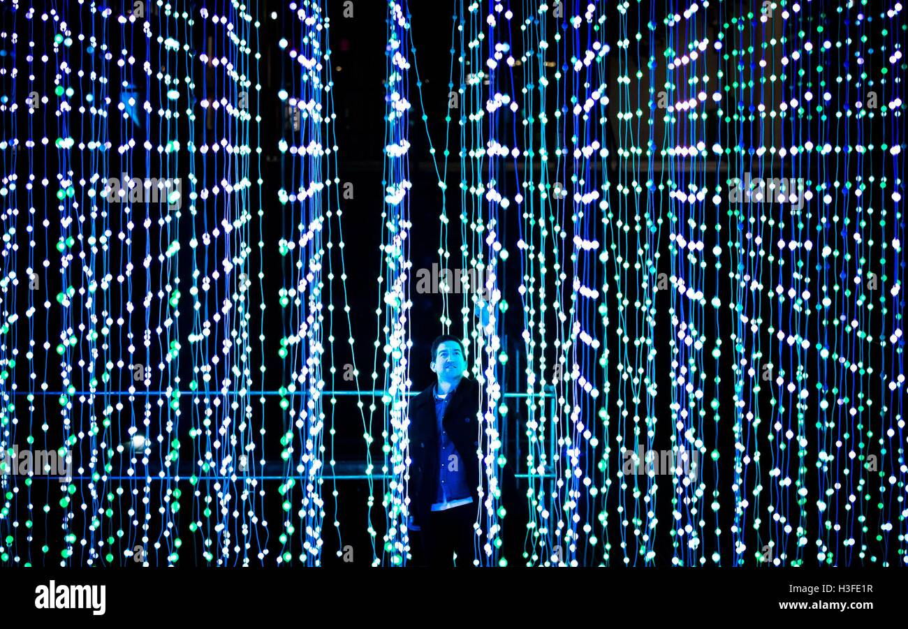 Un membro del pubblico viste una installazione intitolata Luce acqua cielo scuro durante la notte di luce Leeds multi-arts evento. Foto Stock