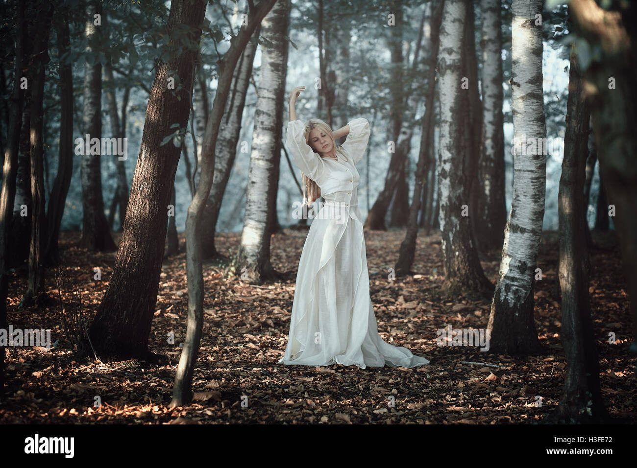 Bella donna dancing in ethereal foresta . Fantasia e surreale Foto Stock