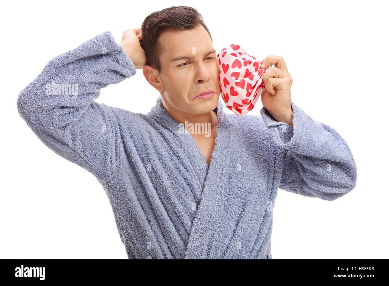 Giovane uomo vivendo un mal di denti e di trattenimento di un elemento refrigerante isolati su sfondo bianco Foto Stock