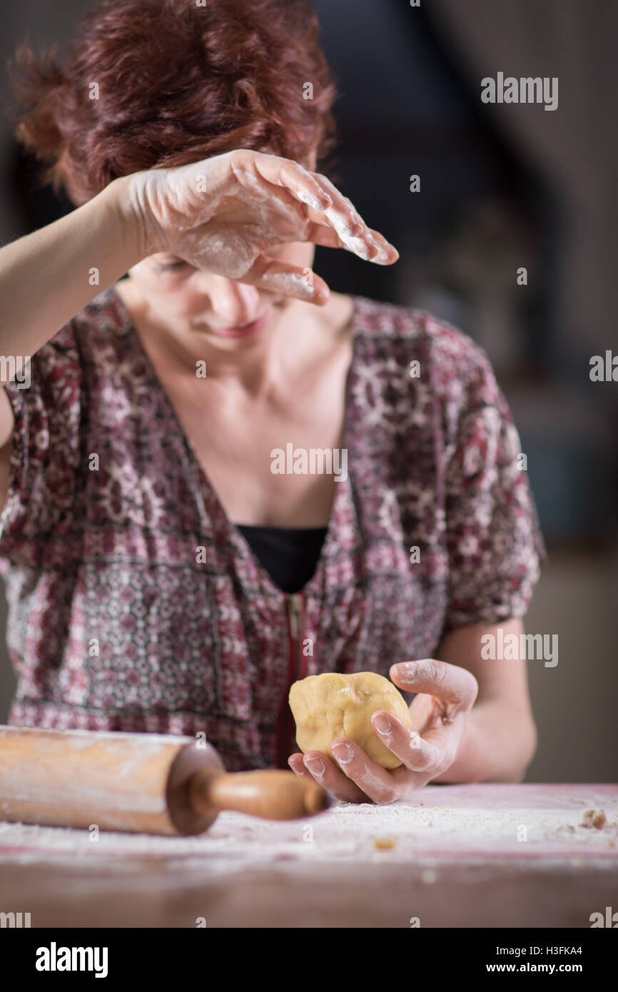 Stanco giovane donna fare una pasta nella sua cucina Foto Stock