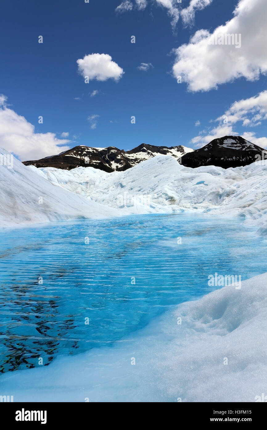 Piccolo lago sul Perito Moreno glaciar formata da estate fusione del ghiaccio con una tipica chiaro di colore blu da assorbimento di luce Foto Stock