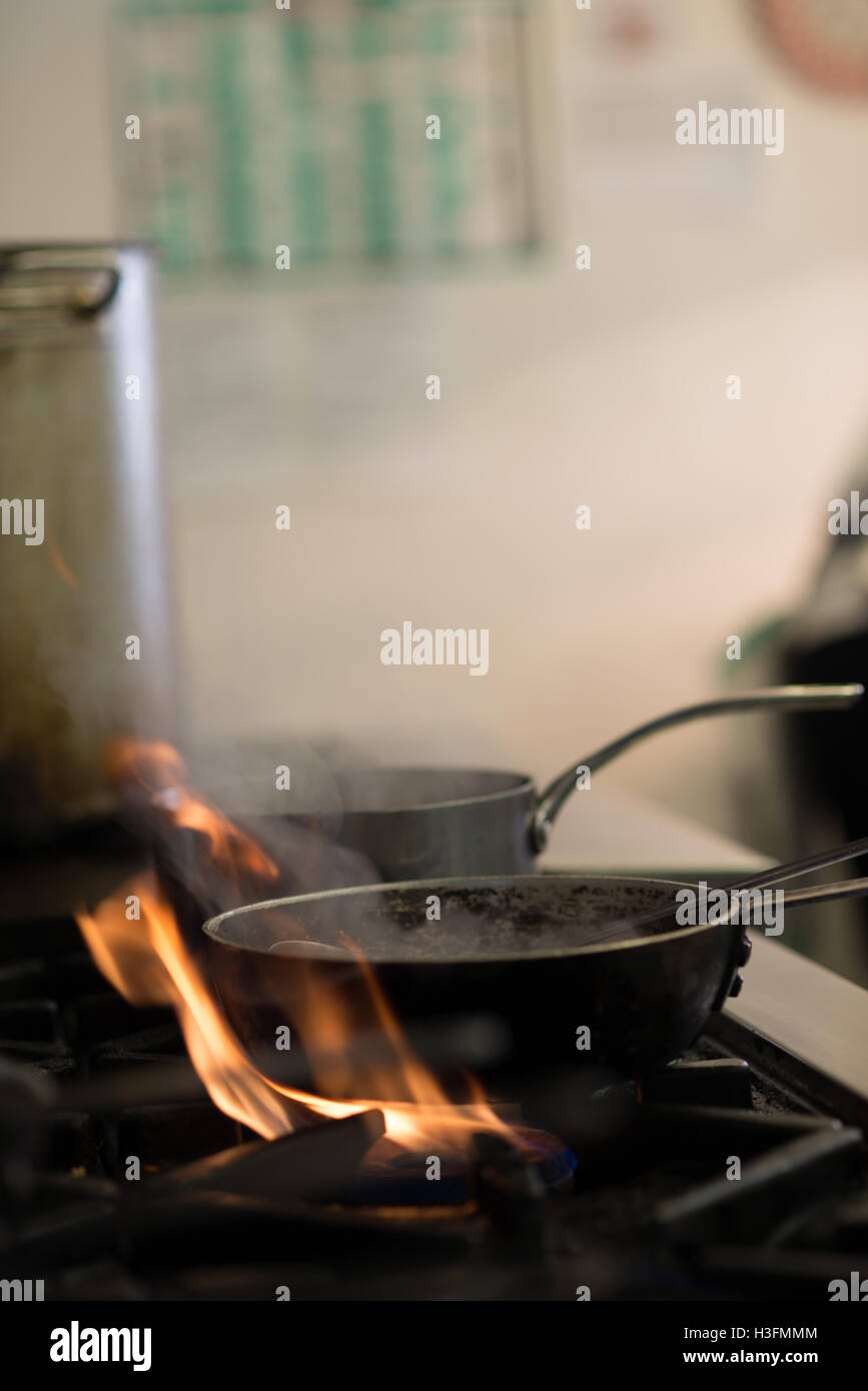 Fumatori pentole sul bruciatore a gas fiamme in una cucina Foto Stock