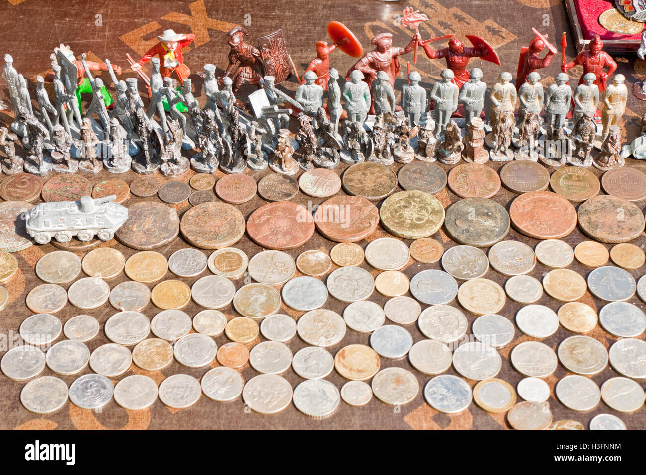 Monete antiche e toy soldiers su una bancarella di un mercato delle pulci di Lviv, Ucraina. Foto Stock