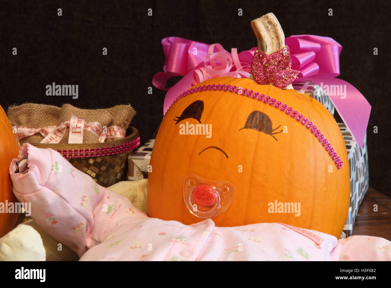 Un felice zucca vestita come una principessa baby accanto al rosa presenta Foto Stock