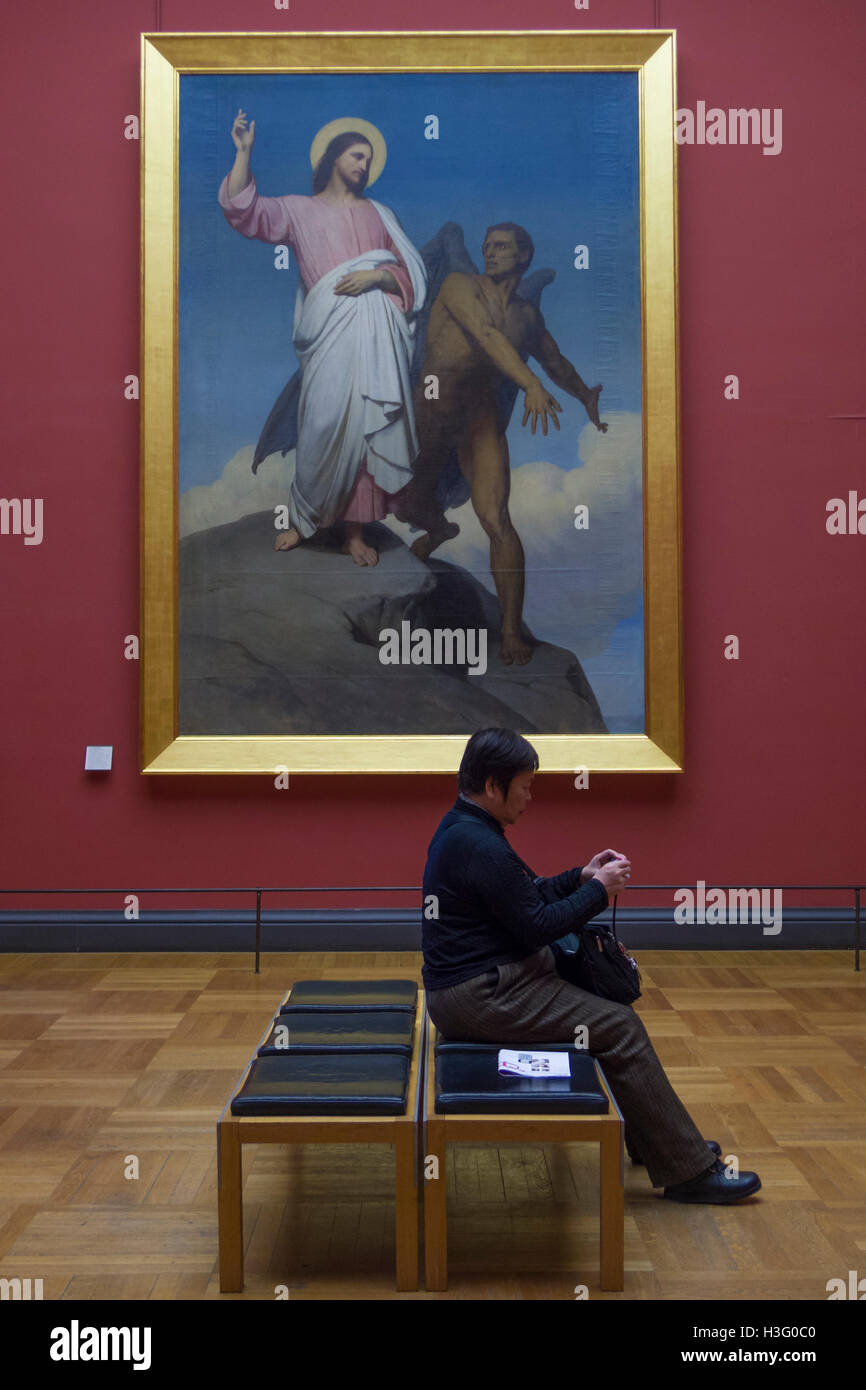 Louvre visitatore seduto davanti a 'tentazione di Cristo " (1854) da Ary Scheffer, Parigi, Francia Foto Stock