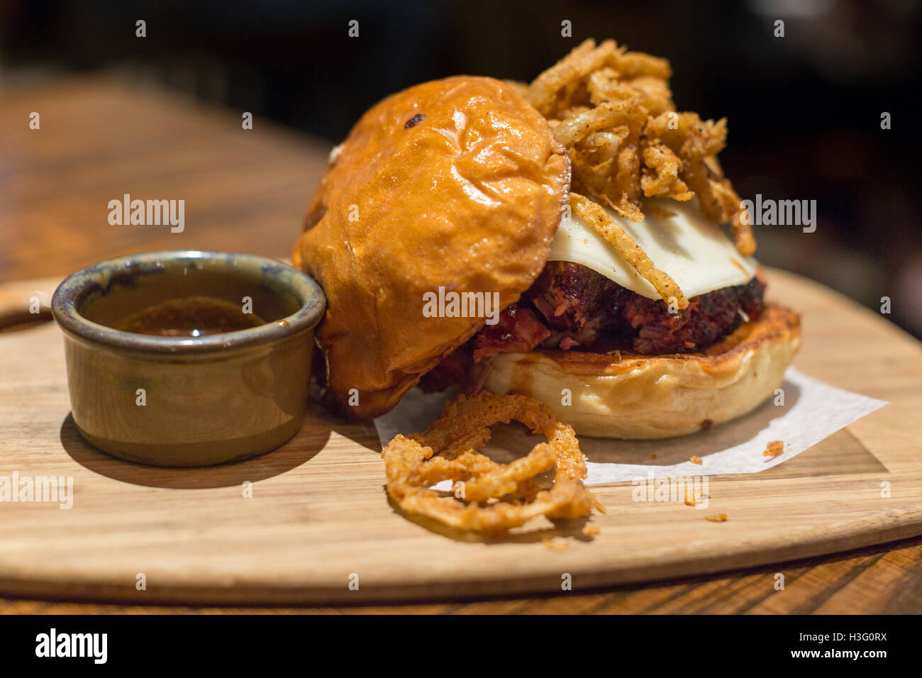 Una punta di petto di manzo in sandwich con cipolle fritte e formaggio Foto Stock