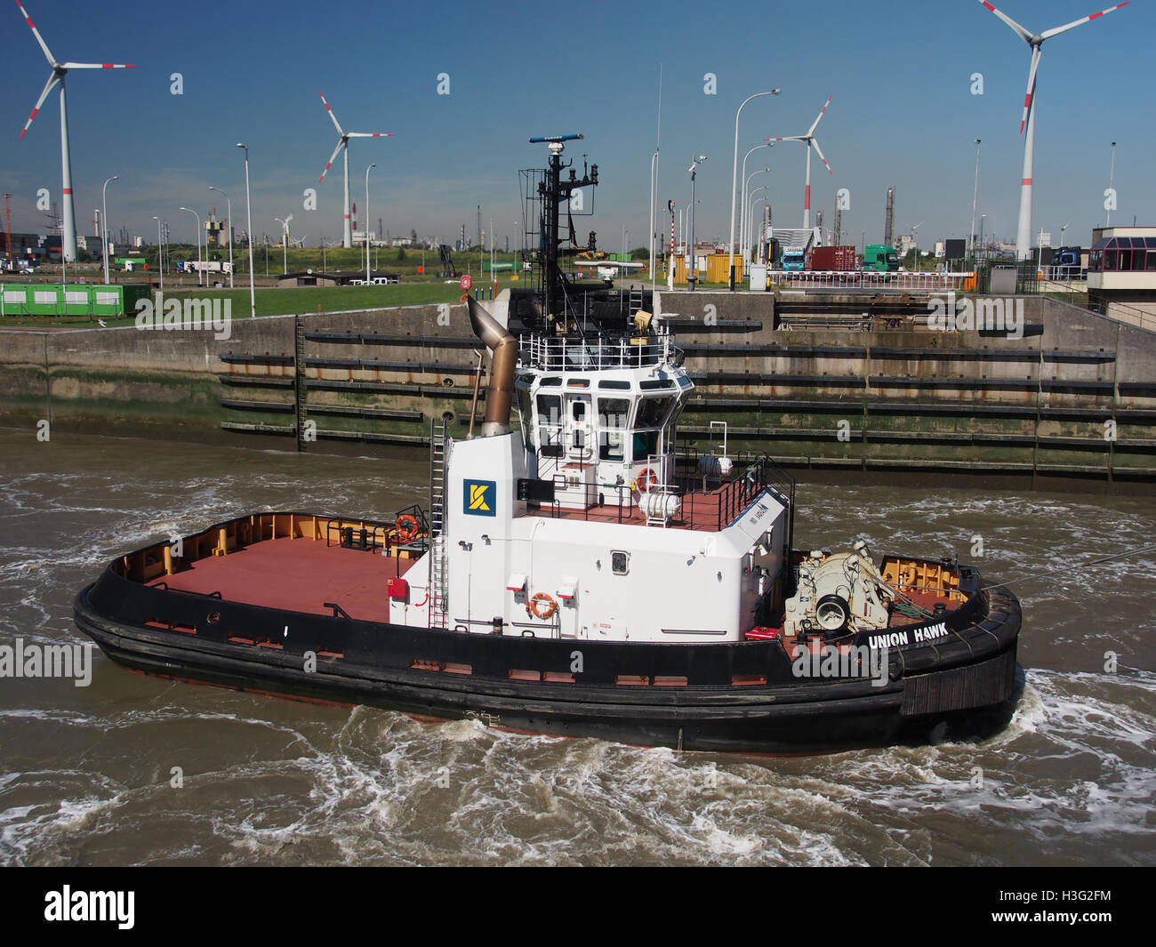 L'immagine mostra il rimorchiatore Union Hawk al porto di Anversa nel 2010. Il rimorchiatore, essenziale per le operazioni portuali, è visto manovrare nel porto, evidenziando il suo ruolo cruciale nella logistica marittima e nelle operazioni di navigazione. Foto Stock