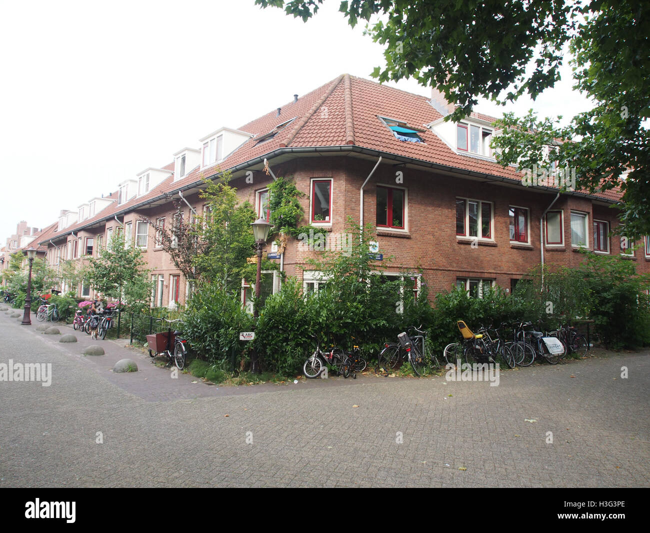 Una fotografia storica scattata all'incrocio tra *Sijsjesstraat* e *Leeuwerikstraat* in una città o in una città dei Paesi Bassi. Questa immagine cattura la vita quotidiana e l'architettura tipica della regione in un'epoca passata. Foto Stock