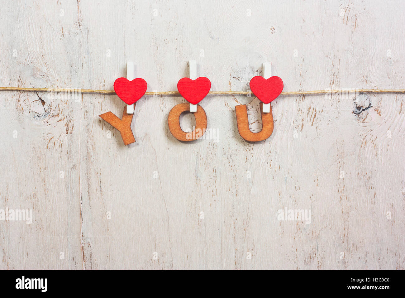 Lettere di legno e di cuore formando la frase che sul legno vecchio sfondo bianco Foto Stock