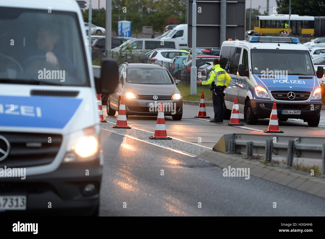 Berlino, Germania. 08 ott 2016. Gli ufficiali di polizia verificare auto arrivando all'aeroporto di Schoenefeld appena al di fuori di Berlino, Germania, 08 ottobre 2016. La polizia è stata accresciuta avviso e serrati a protocolli di sicurezza poiché un sospetto tentativo di attacco terroristico a Chemnitz questa mattina. Circa 30 ufficiali perfettamente insonorizzate le identità dei mezzi di trasporto pubblico di passeggeri e driver inserendo l'aeroporto come parte di una costante ricerca di un sospetto. Foto: MAURIZIO GAMBARINI/dpa Credito: dpa picture alliance/Alamy Live News Foto Stock