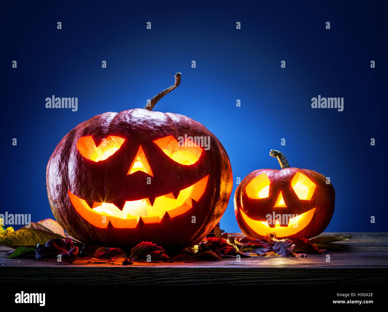 Grinning zucca lanterna o jack-o'-lanterna è uno dei simboli di Halloween. Attributo di Halloween. Sfondo di legno. Foto Stock