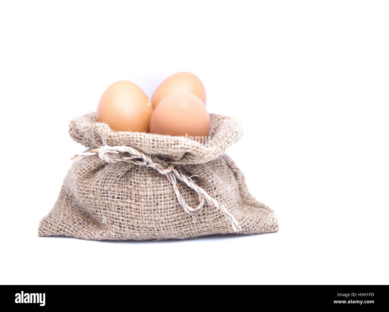 Uova di colore marrone nel sacco marrone su bianco isolato Foto Stock