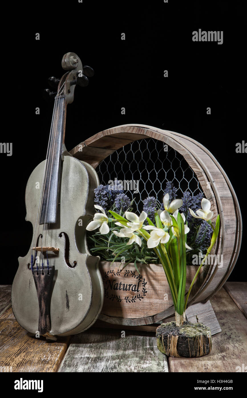 Vecchio violino e fiori su una tavola di legno di sfondo per studio Foto Stock