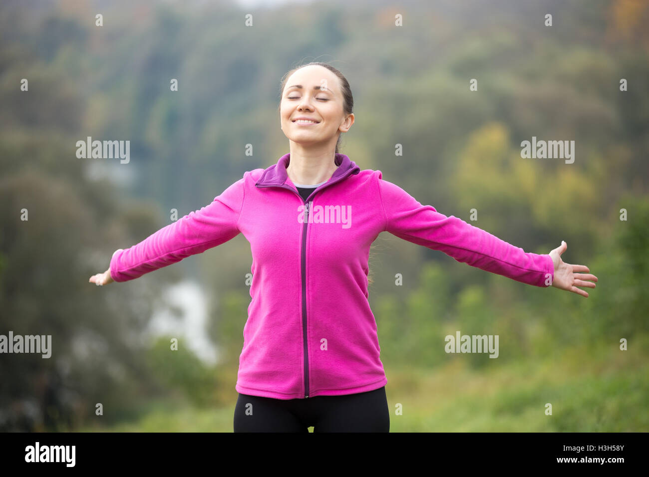 Ritratto di un sorridente giovane donna all'aperto in un abbigliamento sportivo Foto Stock