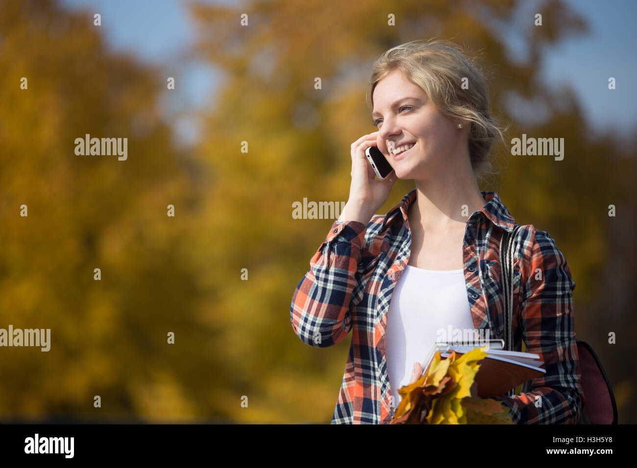 Ritratto di giovane studente attraente outsides, parlando sul suo telefono Foto Stock