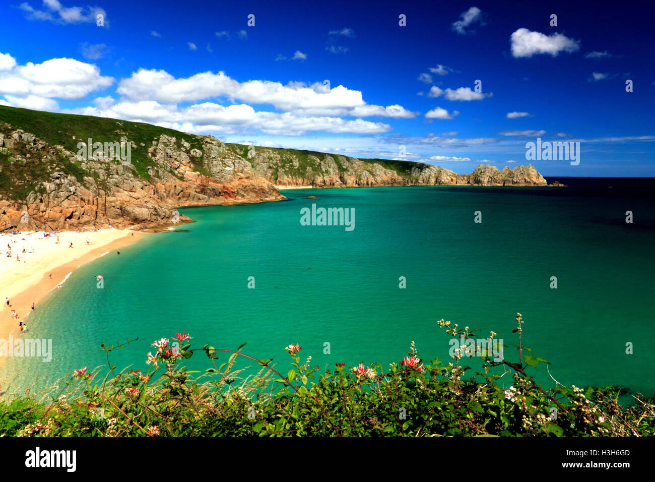 Una sabbiosa spiaggia della Cornovaglia con profonde acque turchesi e scogliere rocciose. Foto Stock