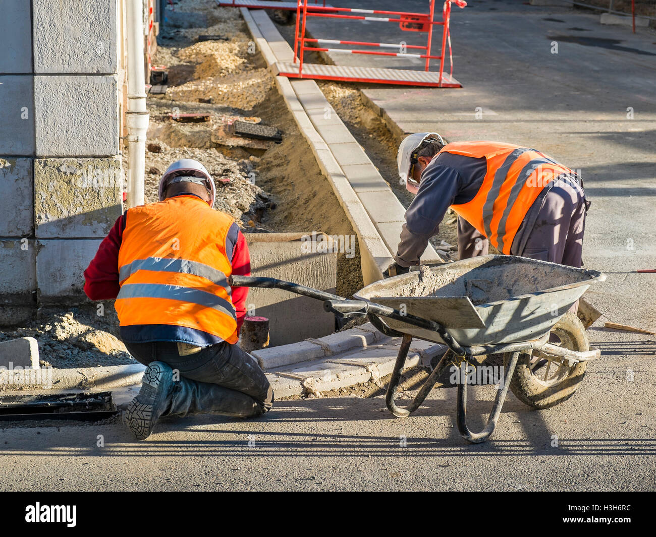 Lavoratori la posa della pavimentazione Pietre di cordolo - Francia. Foto Stock