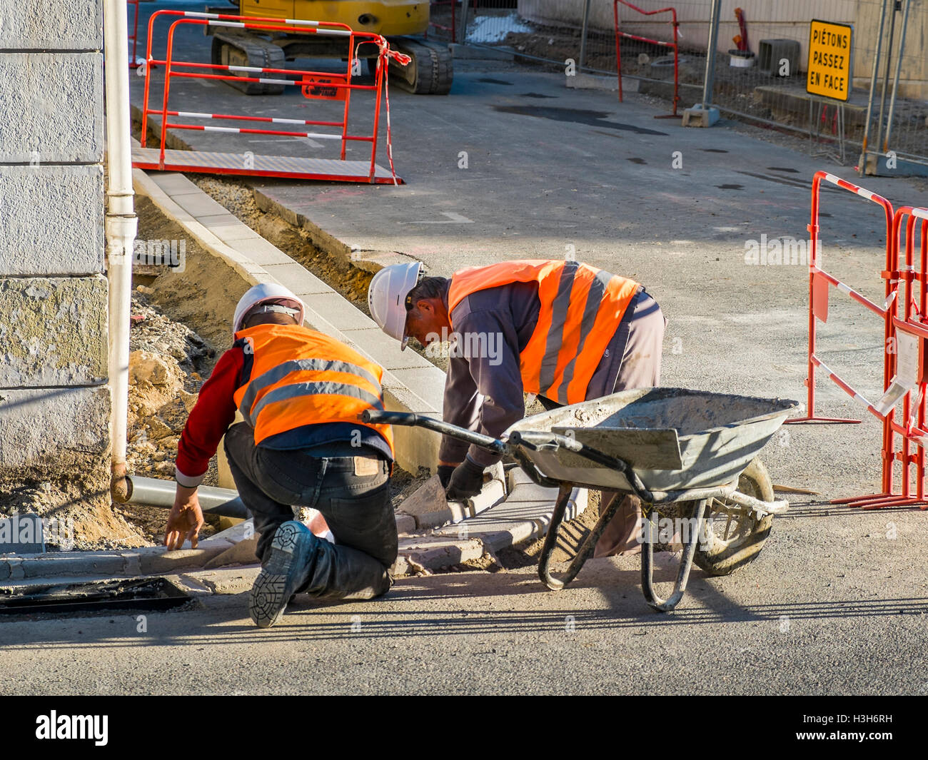 Lavoratori la posa della pavimentazione Pietre di cordolo - Francia. Foto Stock