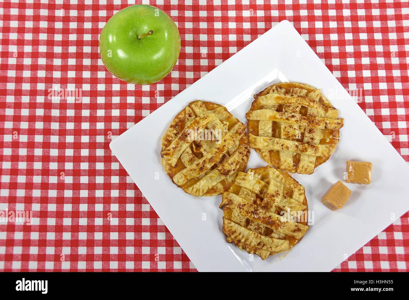 La torta di mele i biscotti con la caramella sul quadrato bianco piastra con mela verde Foto Stock