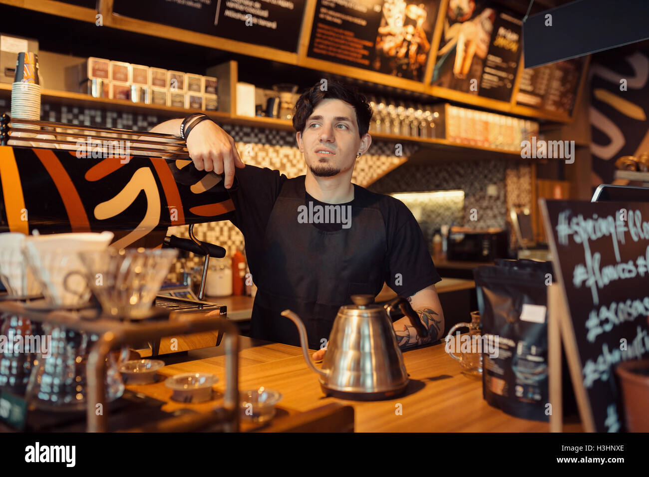 Barista a lavorare in un negozio di caffè Foto Stock