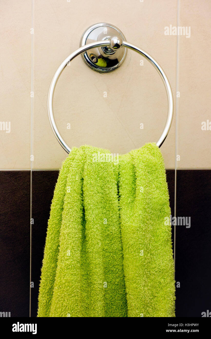 Green towel appeso sul ring di asciugamani in bagno Foto Stock