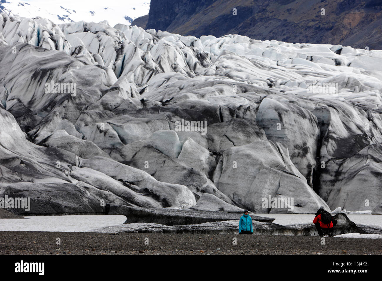 I turisti per scattare delle foto al coperto di cenere Skaftafell ghiacciaio e fine morena, Vatnajokull parco nazionale in Islanda Foto Stock