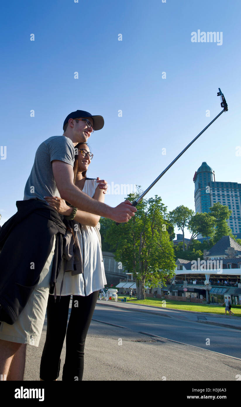 I turisti prendendo un selfie alle Cascate del Niagara Foto Stock