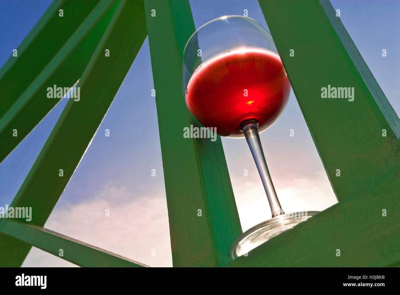 Visualizzazione grafica sul bicchiere di vino rosso sulla veranda alfresco in impostazione di vacanza con il cielo dietro al tramonto Foto Stock