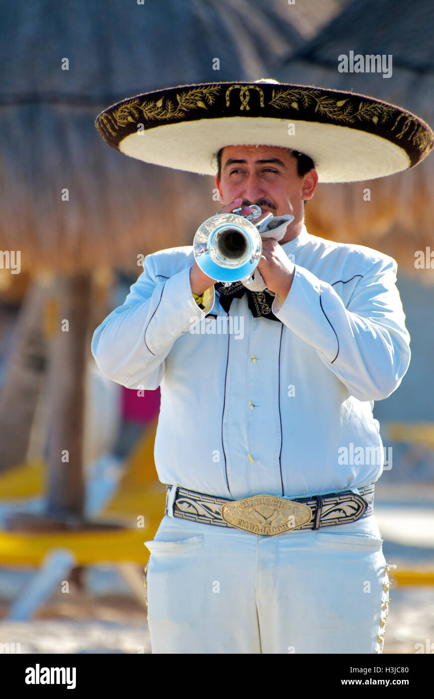 Tromba Mariachi giocatore esegue su Sunny Beach durante le cerimonie che indossa un sombrero Hat & White Suite con benna oro in Messico Foto Stock