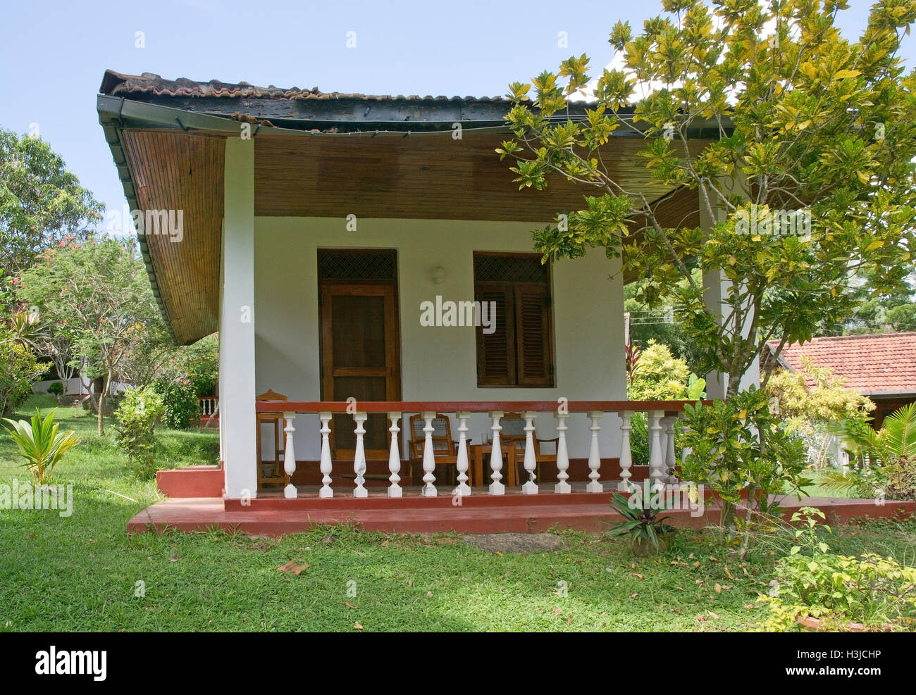 Tipico stile coloniale bungalow con veranda e ampio padiglione nel giardino verde dintorni in dicembre in Sri Lanka, in Asia. Foto Stock