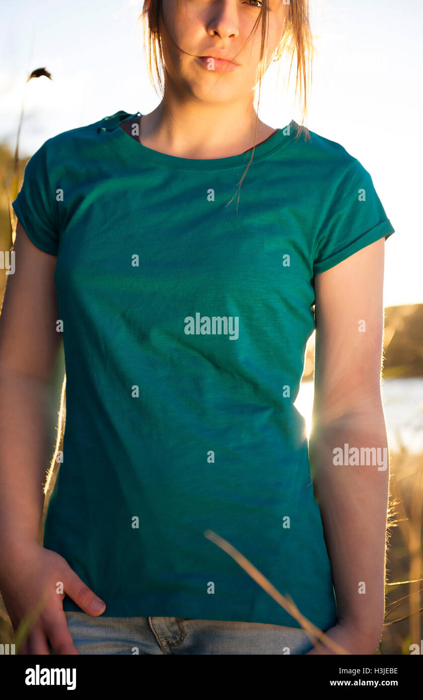 Giovane ragazza al tramonto indossa un fustellato T shirt Foto Stock