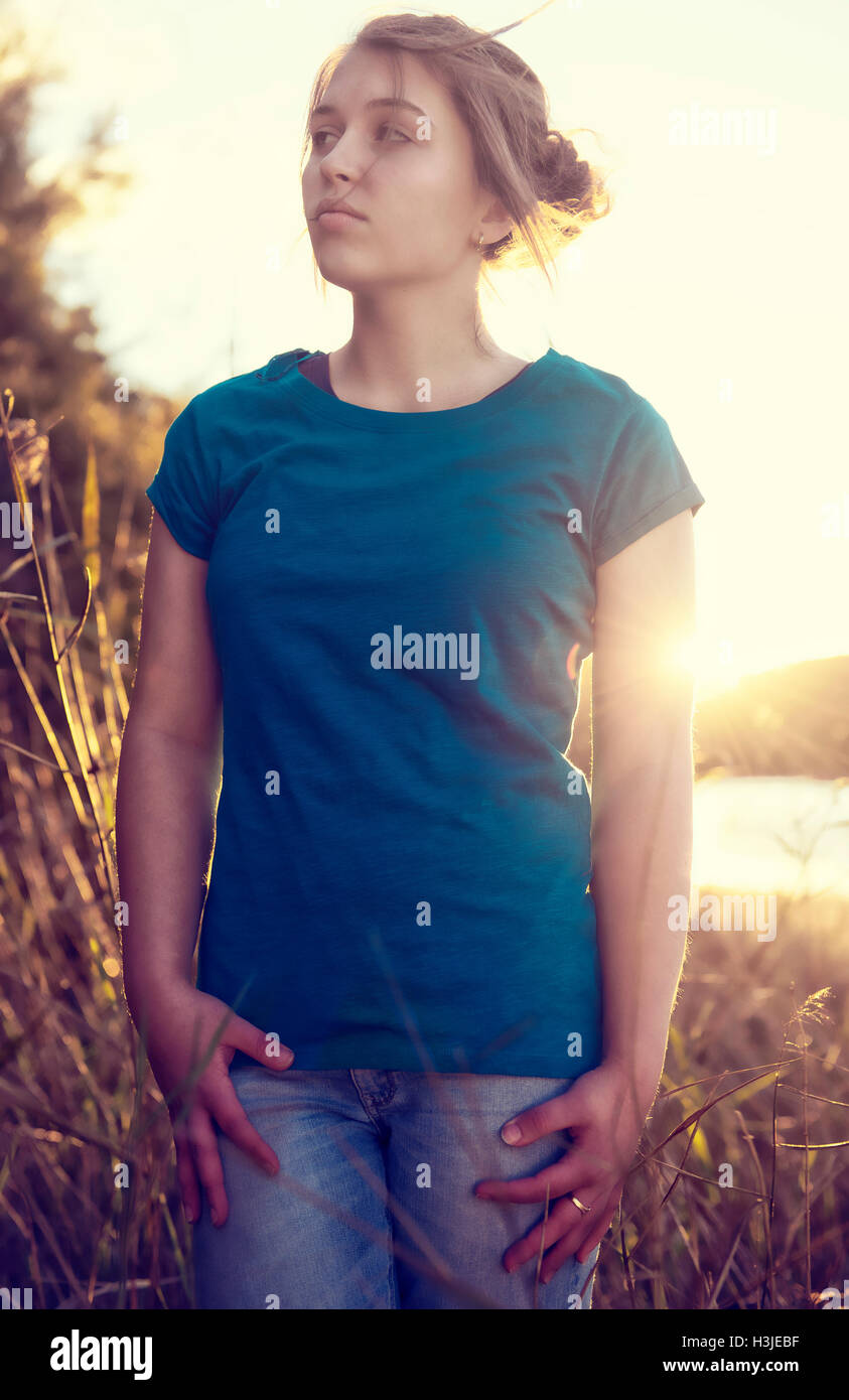 Giovane ragazza al tramonto indossa un fustellato T shirt Foto Stock