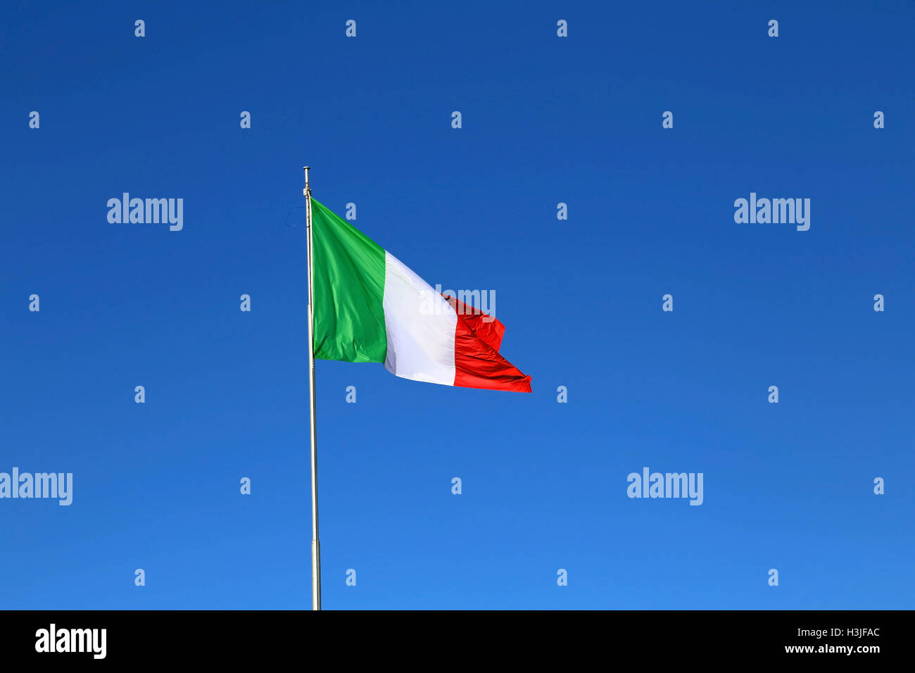 Grande bandiera italiana con i colori bianco e rosso verde e il cielo sfondo blu Foto Stock