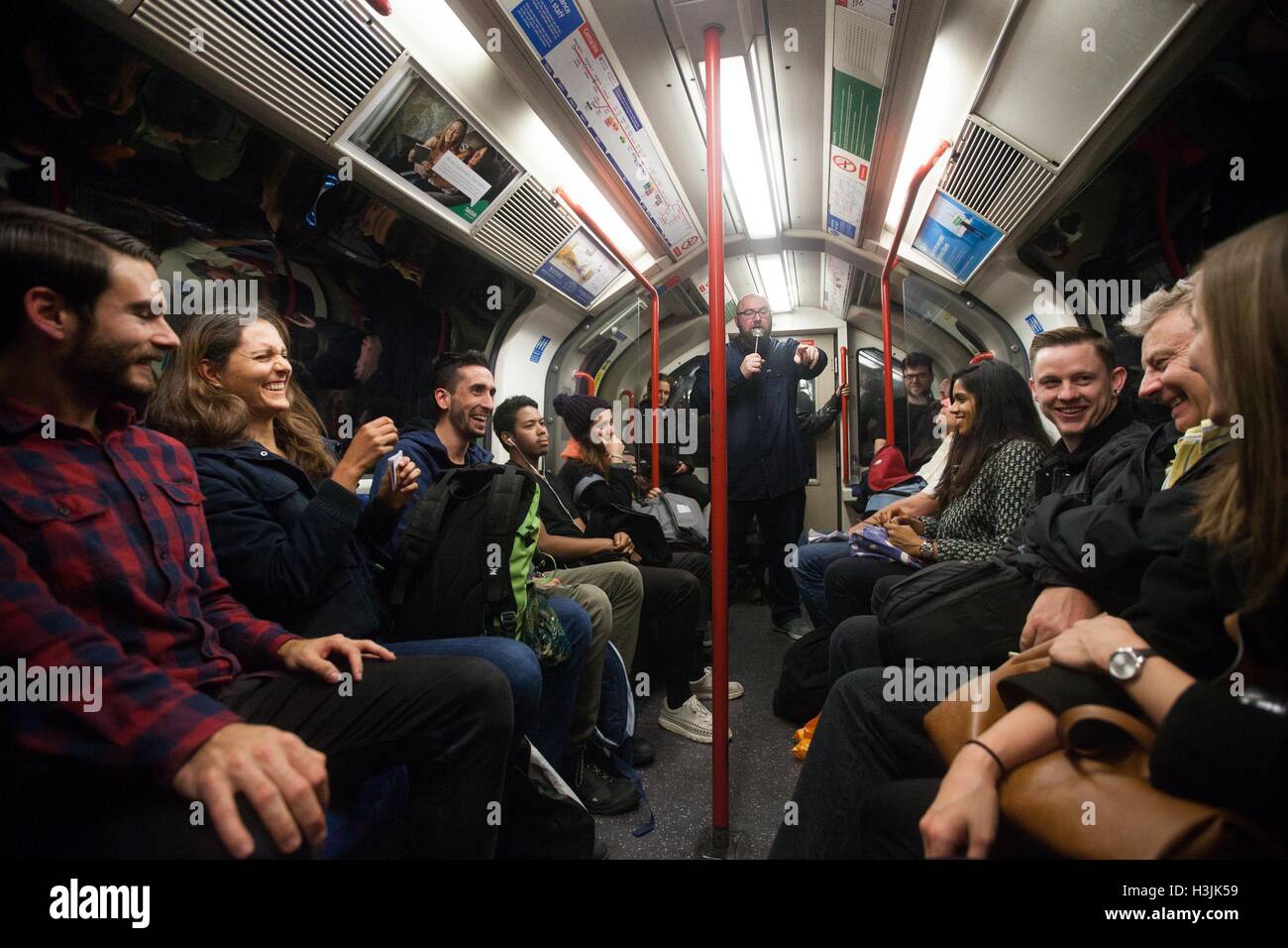 Il comico Scott Gibson (centro) si esibisce sulla metropolitana di Londra, in collaborazione con lastminute.com per lanciare ComedyLine, una serie di spettacoli spontanei in stand-up per celebrare i prossimi spettacoli del Edinburgh Comedy Award al Lyric Theatre il 17, 24 e 31 ottobre. Shepherds Bush, Londra. Foto Stock