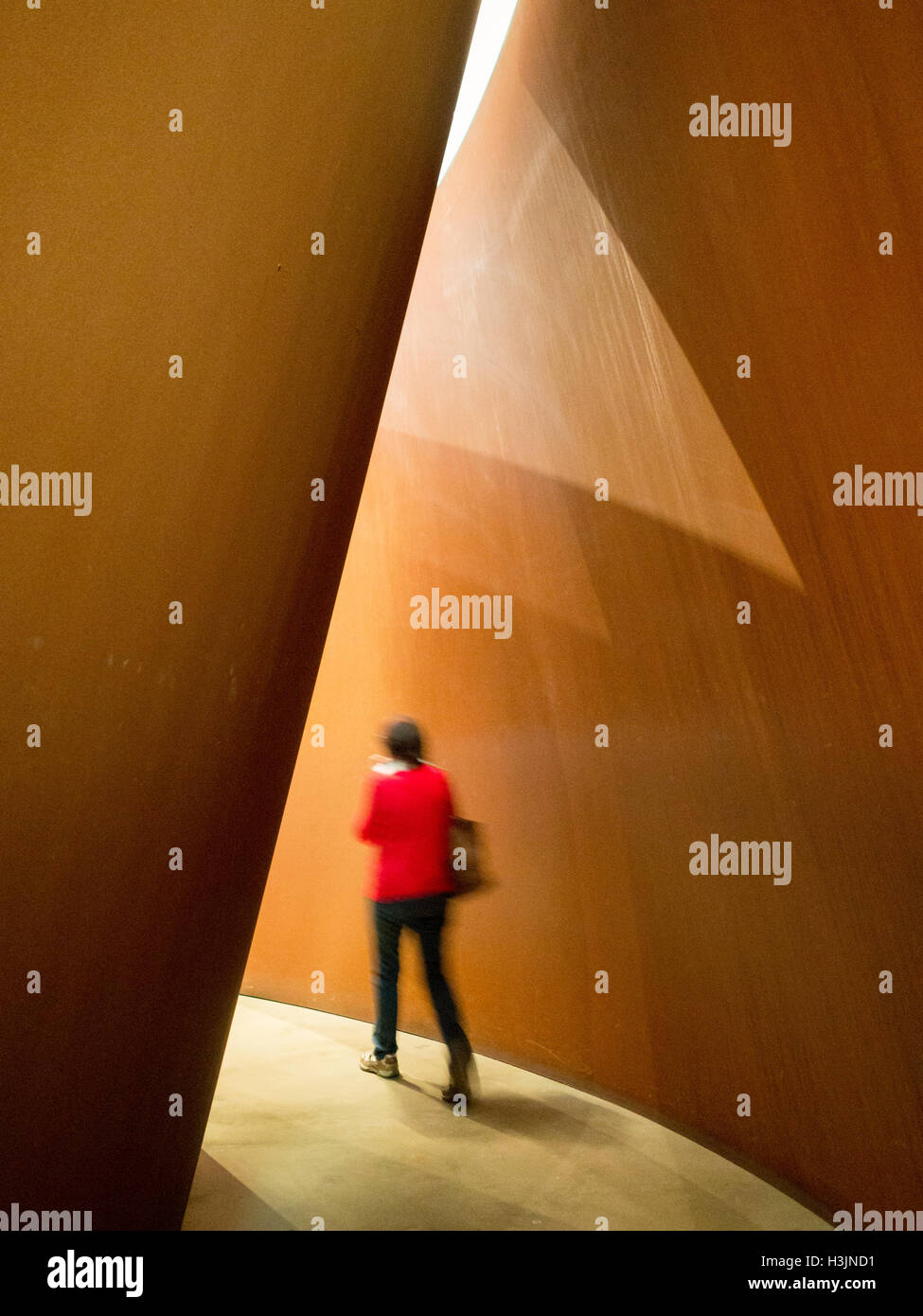 Un visitatore passeggiate all'interno di un Richard Serra sculture in acciaio a Guggenheim Museum Bilbao Foto Stock