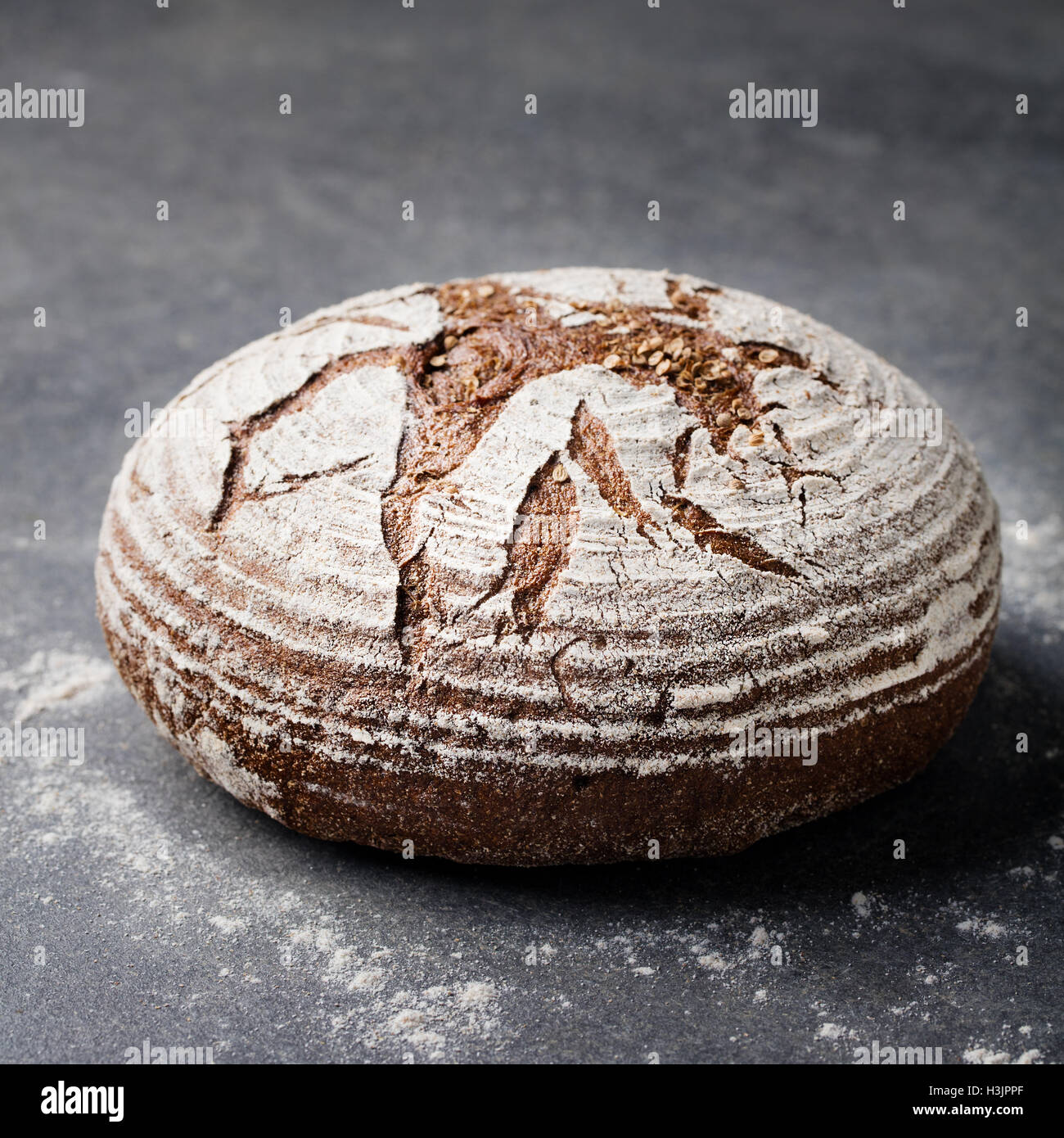 Segale, grano intero pane su una pietra grigia sullo sfondo Foto Stock