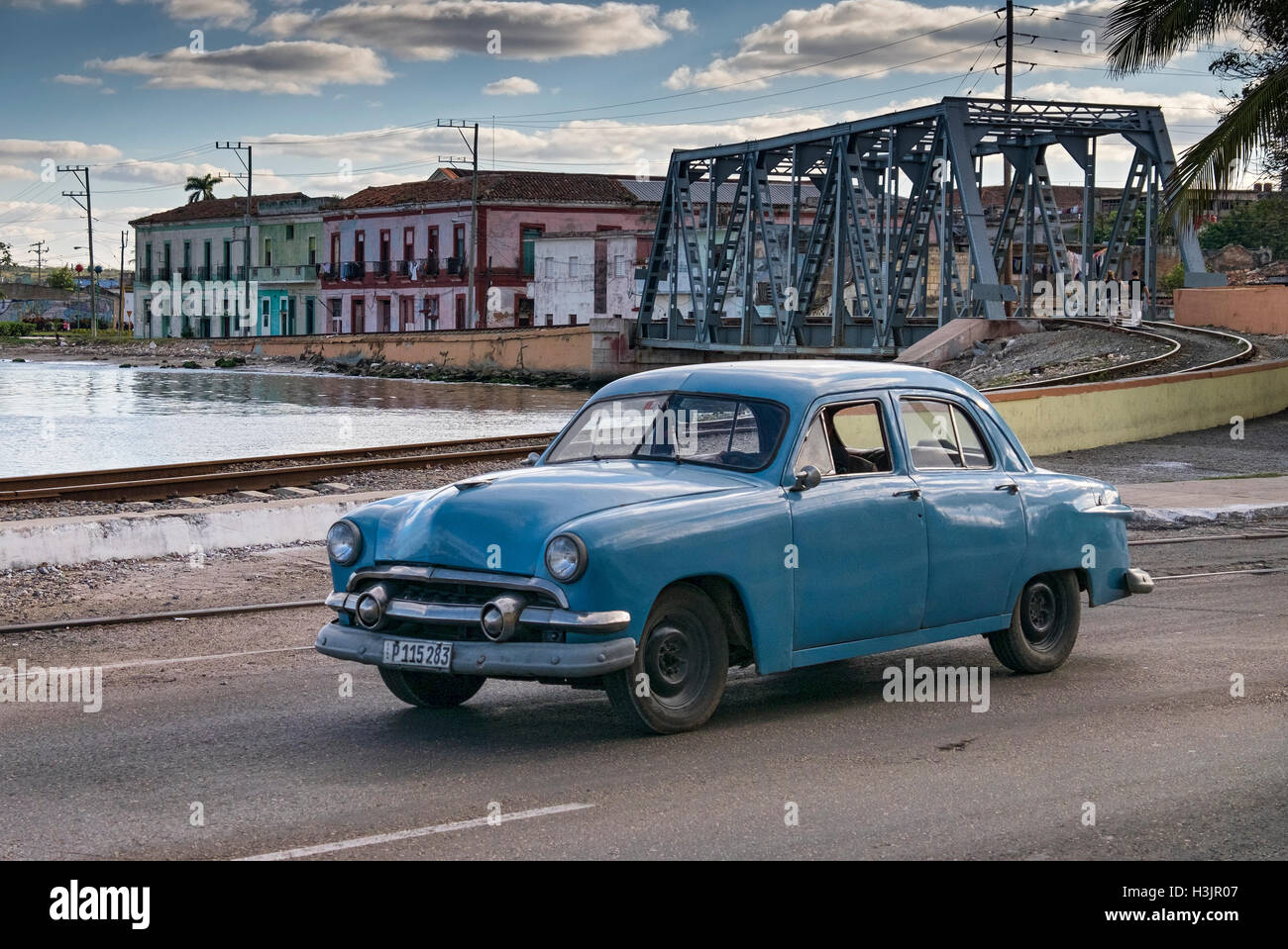 Auto cubano sulla strada calle 272 sostenuta da Rail Bridge & Waterfront edifici, Matanzas, provincia di Matanzas, Cuba Foto Stock