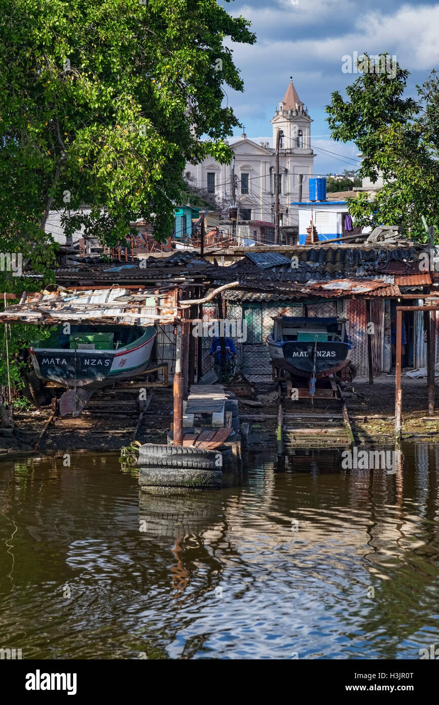 Baracche in barca sul Rio Yumuri River, sostenuta da Iglesia de San Pedro Apostol Chiesa, Matanzas, Cuba Foto Stock