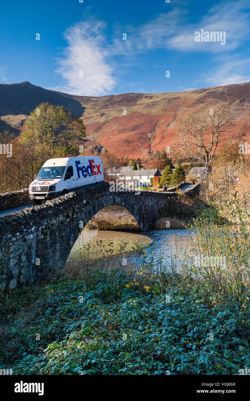 Fed Ex Delivery Van attraversando il ponte di Grange in autunno, Grange di Borrowdale, nel distretto del lago, Cumbria, England, Regno Unito Foto Stock