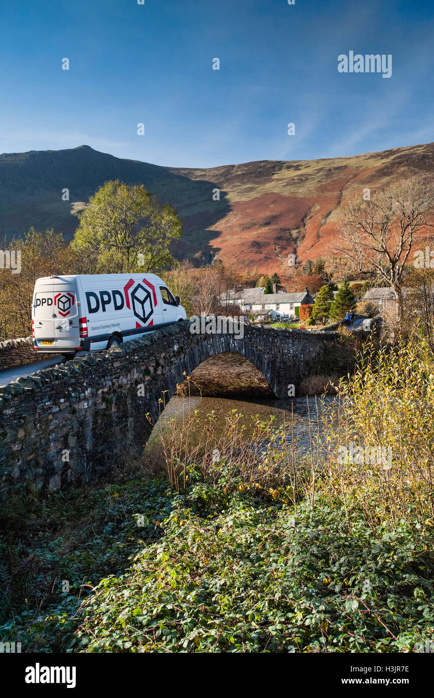Consegna DPD Van attraversando il ponte di Grange in autunno, Grange di Borrowdale, nel distretto del lago, Cumbria, England, Regno Unito Foto Stock
