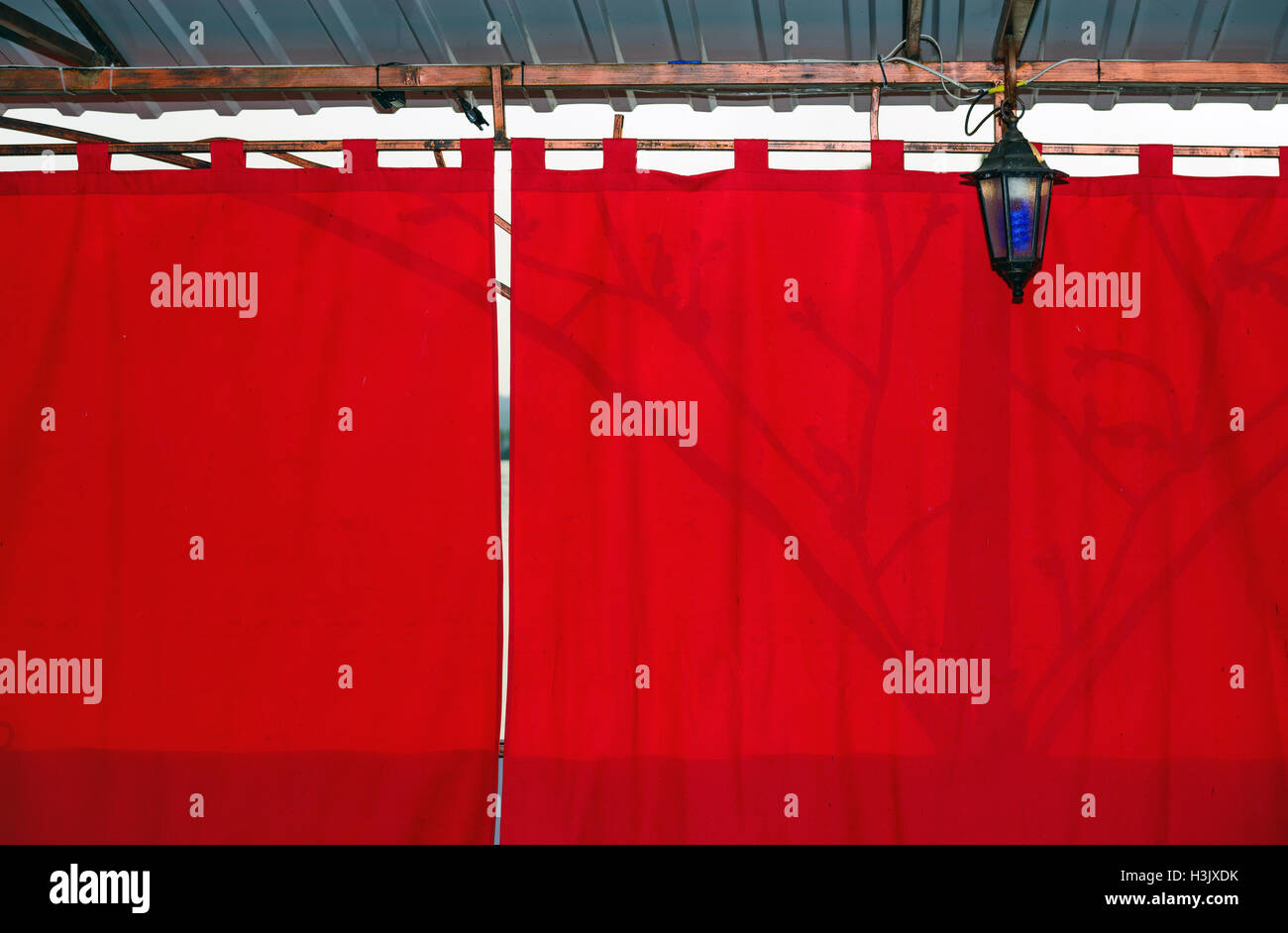 Rosso brillante tenda parasole in background retroilluminati da luce solare. Foto Stock